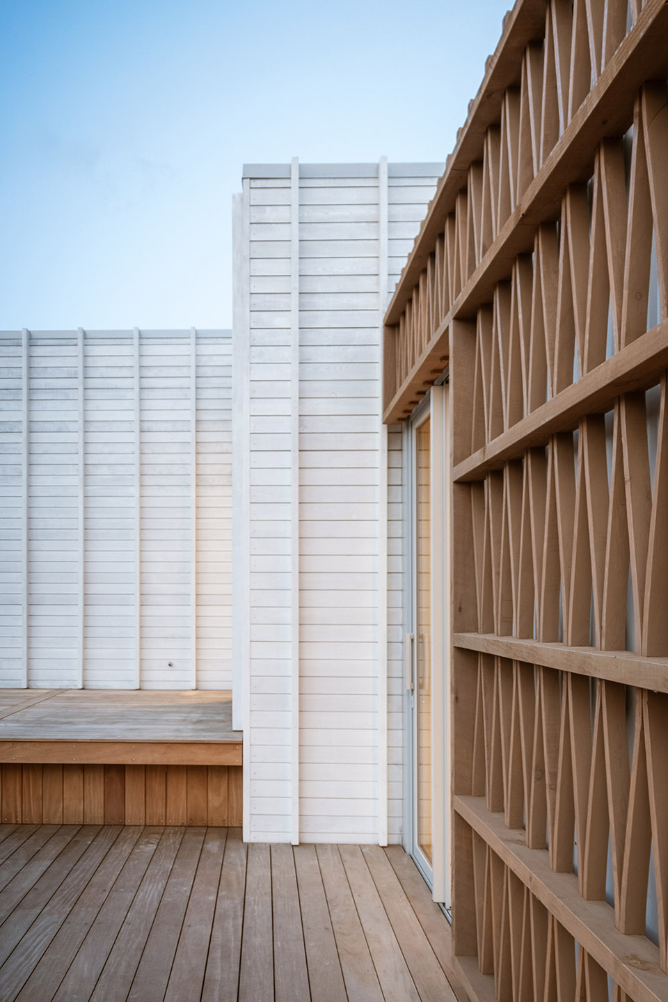 Akitu IV deck detail with pale vertical cladding beside the curved timber rainscreen and its repeating bent timber pattern.