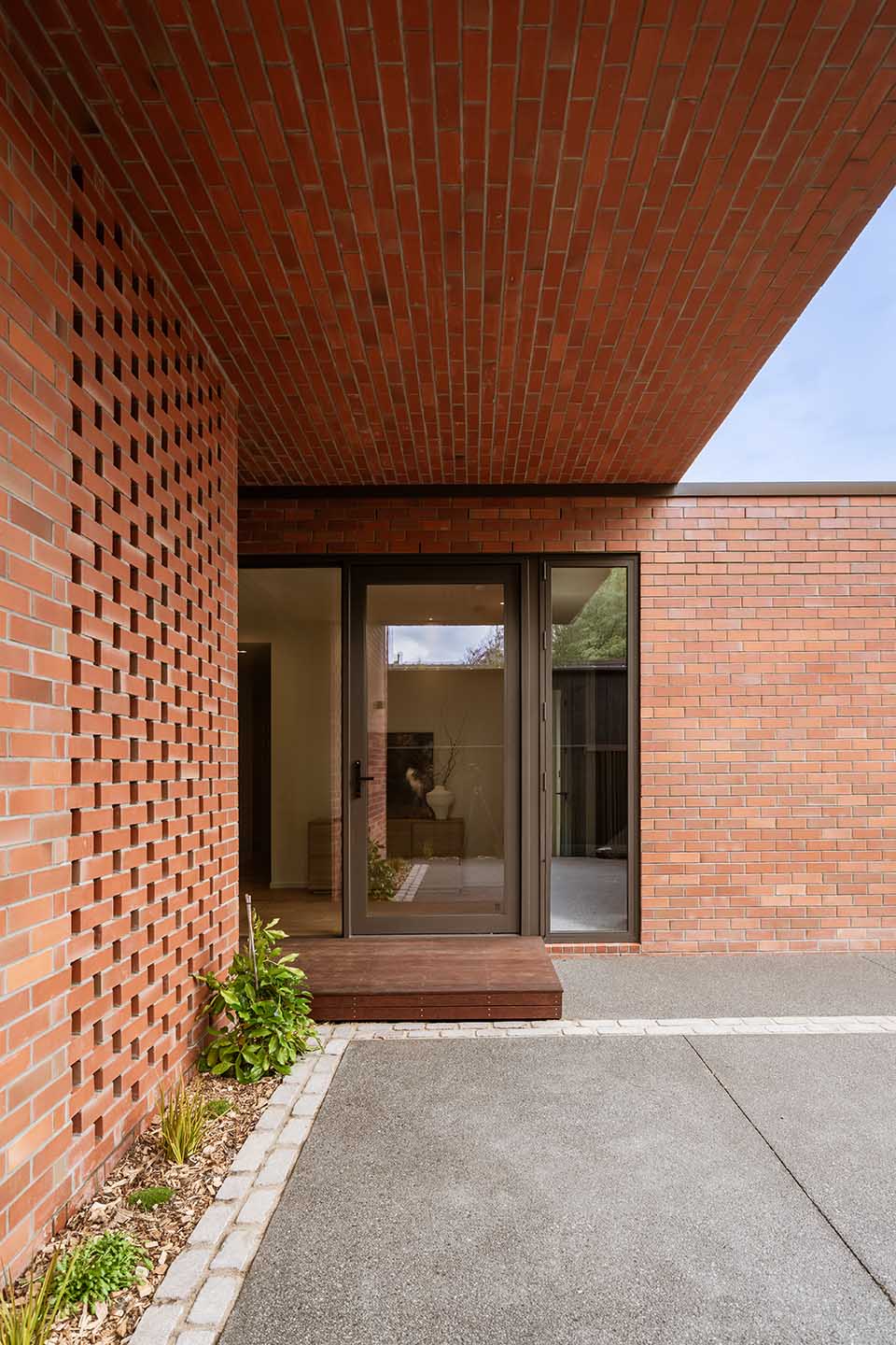 Bryndwr II entrance with perforated brick screening, deep brick soffit and glazed doorway opening from the courtyard.