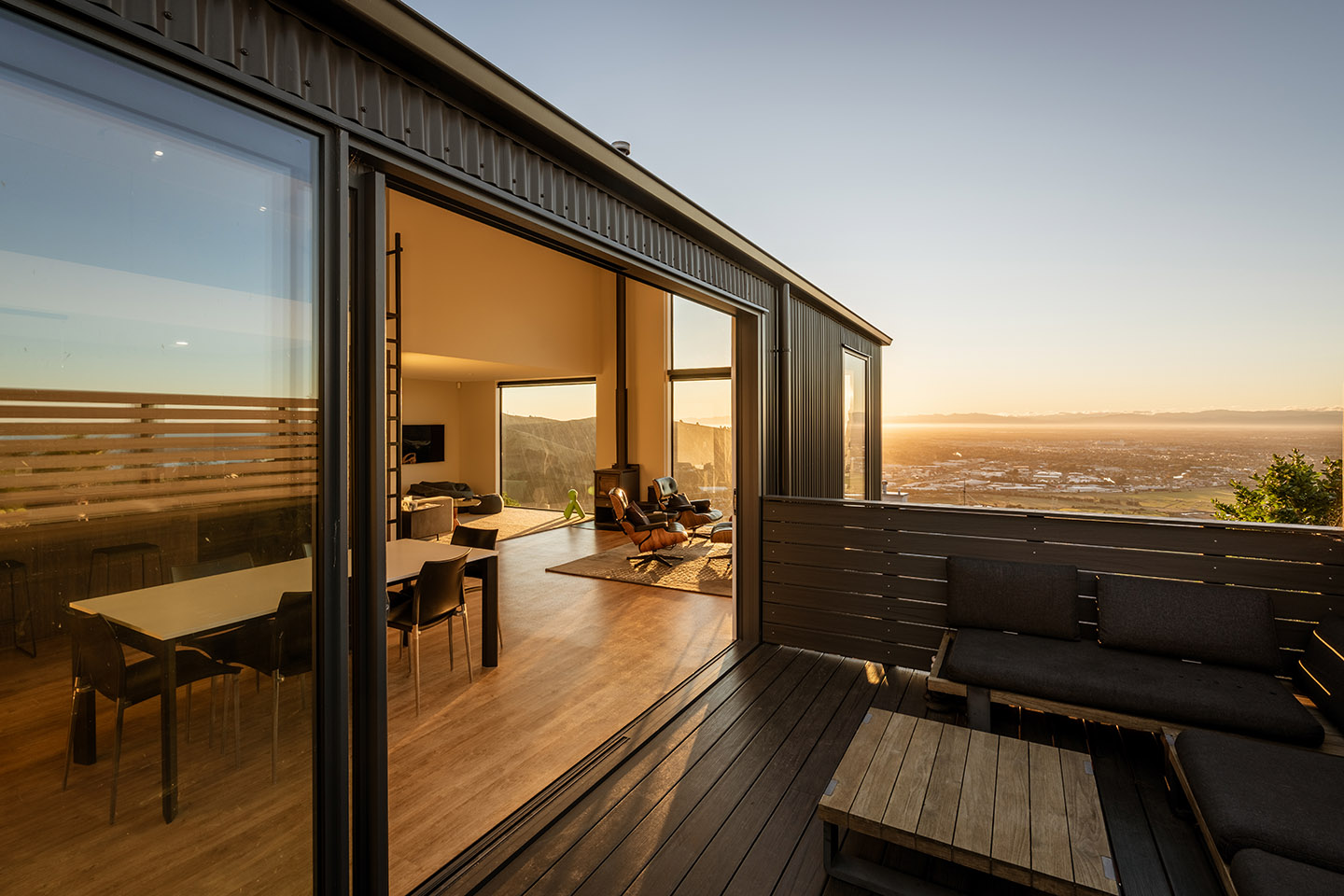 Major Hornbrook II deck opening directly to the dining and living area, with broad views across Christchurch and the distant coast.